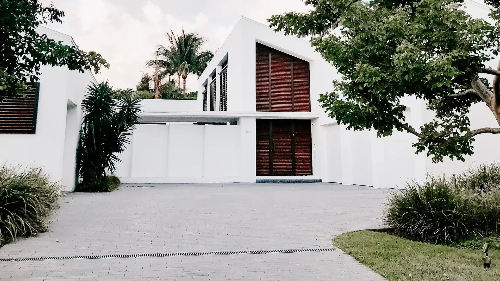 Clean paver driveway in front of a modern house